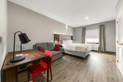a hotel room with a bed and a desk at Hawthorn Extended Stay by Wyndham College Station in College Station