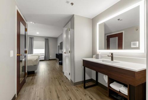 a bathroom with a sink and a bed at Hawthorn Extended Stay by Wyndham College Station in College Station