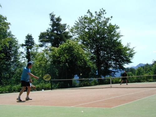 two people playing tennis on a tennis court at Steinegger Eppan in Appiano sulla Strada del Vino