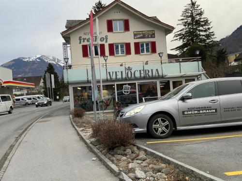 a car parked in front of a building on a street at Motel Restaurant Freihof in Näfels