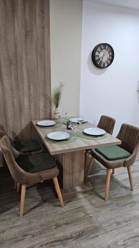 a dining room table with two chairs and a clock at Silver Dream 2 in Veliko Gradište