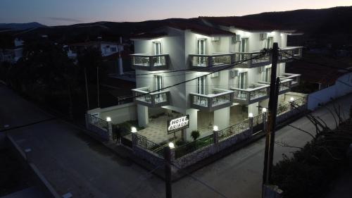 un edificio bianco con luci sul lato di HOTEL ARIADNI a Ayia anna