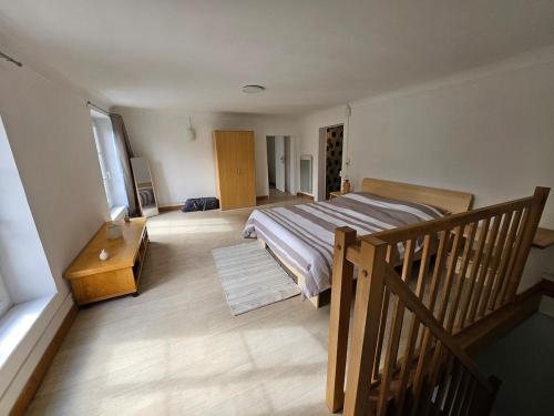 - une chambre avec un grand lit et un escalier en bois dans l'établissement Maison à louer, à Insming