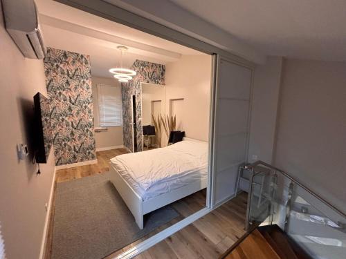 une chambre avec un lit et un grand miroir dans l'établissement Appartement au centre du Port de Bonifacio, à Bonifacio