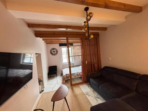 a living room with a couch and a tv at Appartement au centre du Port de Bonifacio in Bonifacio