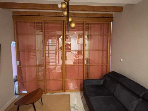 a living room with a couch and a glass door at Appartement au centre du Port de Bonifacio in Bonifacio