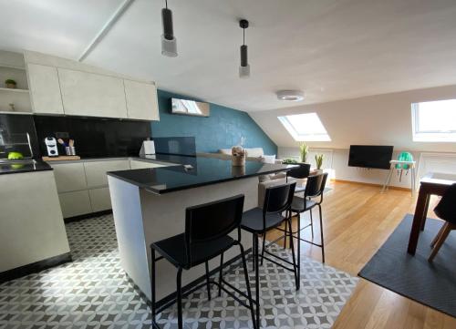 a kitchen with a counter and chairs in a room at Ático 22 - céntrico, aire acondicionado y parking in Vilagarcia de Arousa