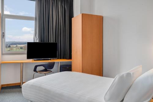 a bedroom with a bed and a desk with a computer at B&B HOTEL Barcelona Mollet Porta de Gallecs in Mollet del Vallès