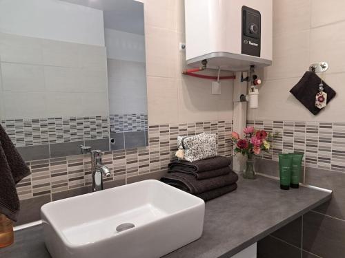 ein Badezimmer mit einem weißen Waschbecken und einem Stuhl in der Unterkunft Appart Béziers - Campagne de Montimas in Béziers