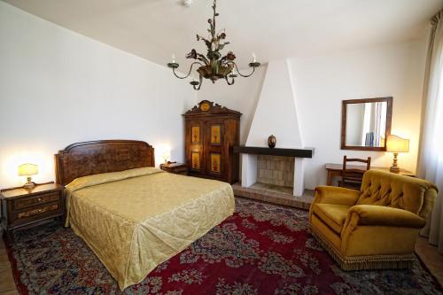sypialnia z łóżkiem, krzesłem i żyrandolem w obiekcie Hotel Luna w mieście San Felice sul Panaro