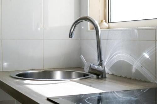 a kitchen sink with a faucet on a counter at Appartement Quartier les Presidents - 2-4 personnes in La Rudelière