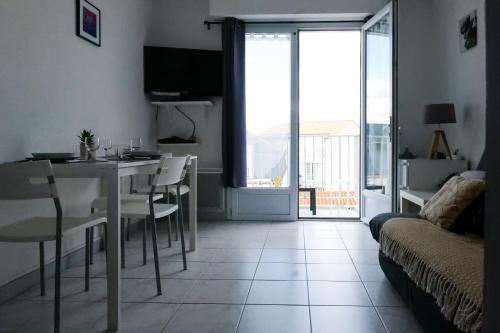 a living room with a table and a room with a view at Appartement Quartier les Presidents - 2-4 personnes in La Rudelière
