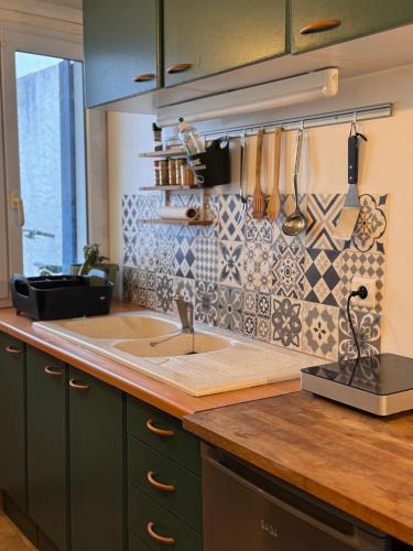 une cuisine avec un évier et un plan de travail dans l'établissement Tiny House dans la verdure et le calme, à Pornichet