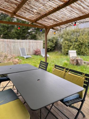 - une table et des chaises sur une terrasse avec un parasol dans l'établissement Tiny House dans la verdure et le calme, à Pornichet