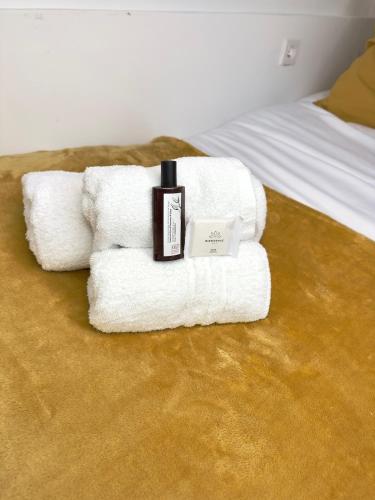 une pile de serviettes posée sur un lit dans l'établissement Charmant appartement proche Paris Champs Élysées - Wifi, à Asnières-sur-Seine