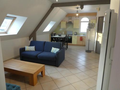un salon avec un canapé bleu et une table dans l'établissement LE BRIDGE, à Bénouville