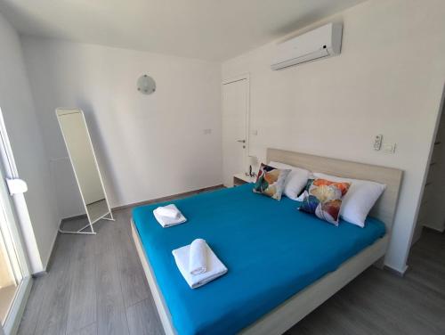 a bedroom with a blue bed with two towels on it at Blauer Horizont in Povljana