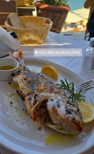 a plate of food with a fish on a table at TO VOTSALO-beach side studios & taverna in Karpathos Town