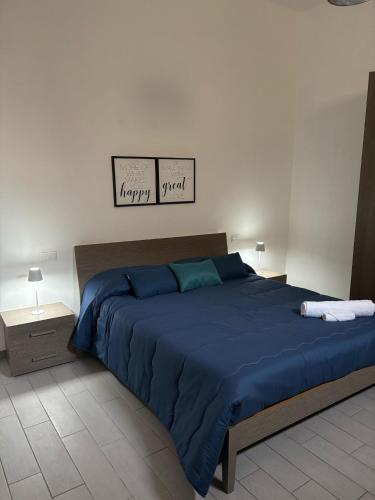 a bedroom with a large bed with blue sheets at Fridea in Trapani