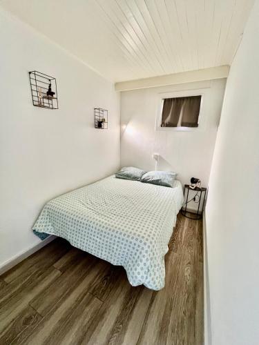 une chambre avec un lit dans une pièce blanche dans l'établissement T2 avec terrasse ombragée et parking À 100m de la plage, à Valras-Plage