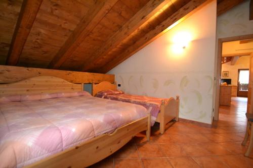 a bedroom with two beds and a wooden ceiling at Residence Casa Federica in Valfurva