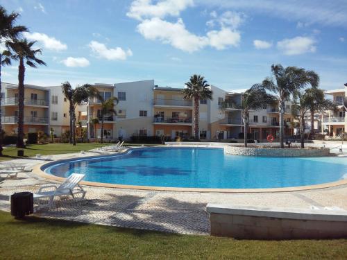 a large swimming pool with palm trees and buildings at Philips Flat in Alvor