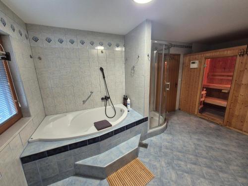 a large bathroom with a tub and a shower at Bella Hiša in Sromlje