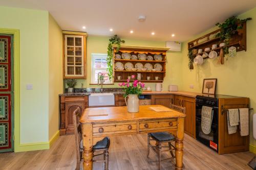 a kitchen with a wooden table with flowers on it at Tredodridge Barn Retreat in Saint Nicholas