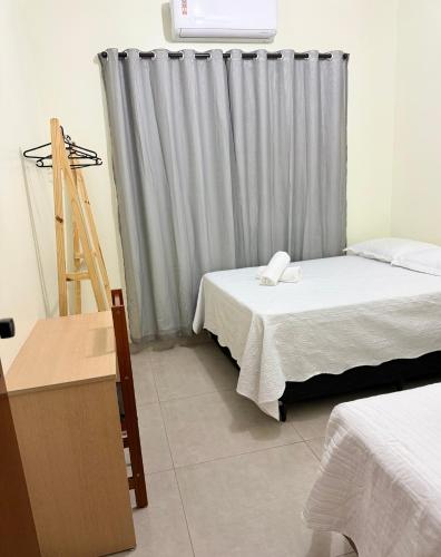 a room with two beds and a ladder and a window at Espaço aconchego in Sinop