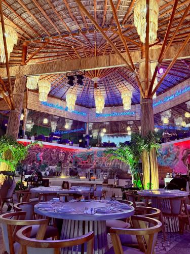 a restaurant with tables and chairs and a ceiling at Departamento La mejor vista de Acapulco en CasaBlanca Grand in Acapulco