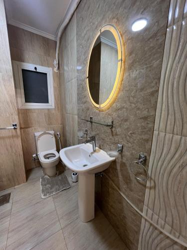 a bathroom with a sink and a toilet and a mirror at فيلا في مدينتي in Madinaty