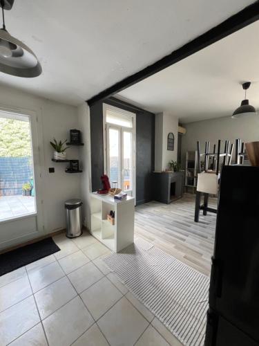 un salon avec une grande fenêtre et une table dans l'établissement Grand appartement avec terrasse centre ville Arles, à Arles