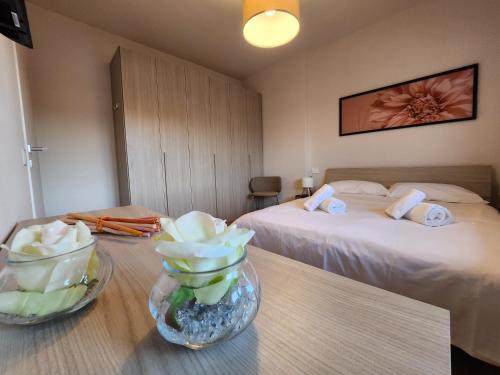 una camera d'albergo con due letti e un tavolo con fiori di Attico Fibonacci - Affitti Brevi Italia a Pisa
