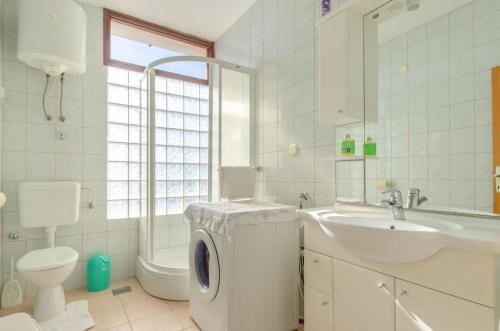 a bathroom with a washing machine and a sink at House Vila Petra in Blato
