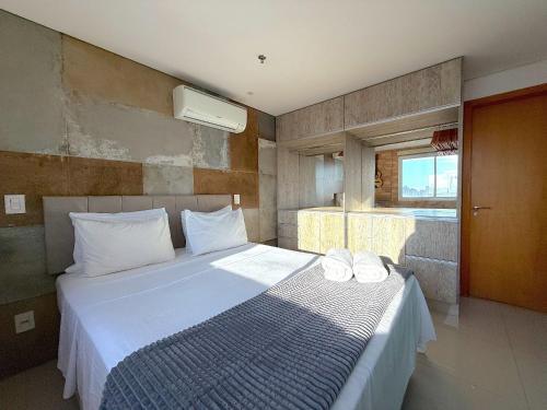 a bedroom with a bed with white sheets and a window at iFlat brookfield Towers BTLX2817 Jardim Goiás in Goiânia
