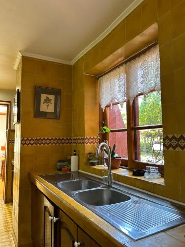 a kitchen with a sink and a window at EL REFUGIO DE NAELA in Coltauco