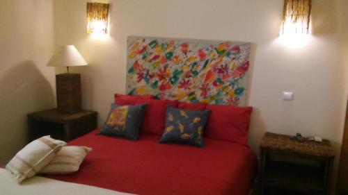 a bedroom with a red bed with a painting on the wall at Philips Flat in Alvor