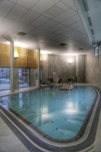 une grande piscine avec de l'eau bleue dans un immeuble dans l'établissement APPARTEMENT T2 4 PERSONNES Wifi et Climatisation, à Luchon