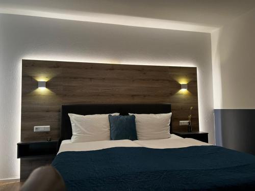 a bedroom with a large bed with a wooden headboard at Landhotel Rauber Sankt Wendel in Oberthal