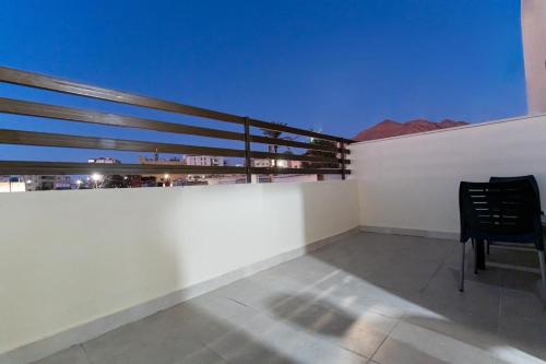 a black chair sitting on top of a white wall at Old town apartment 2 in Aqaba