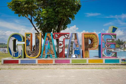 a large sign that says open on a sidewalk at Hotel Casa Verde Guatapé in Guatapé