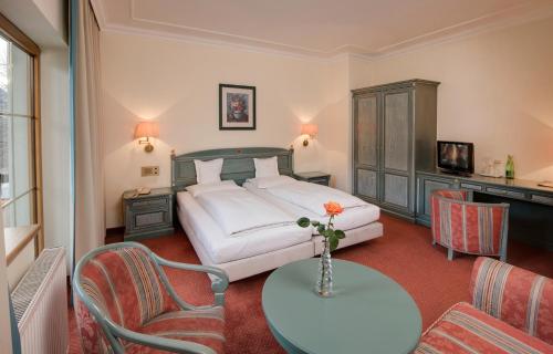 a bedroom with a bed and a table and chairs at Der Reschenhof in Mils bei Hall