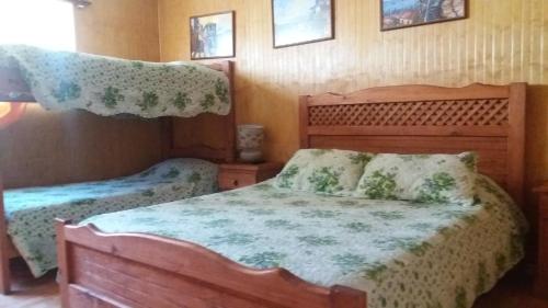 a bedroom with two beds and two pictures on the wall at Hotel San Juan in Coquimbo