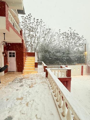 a person standing outside of a building in the snow at SkyRidges in Srinagar