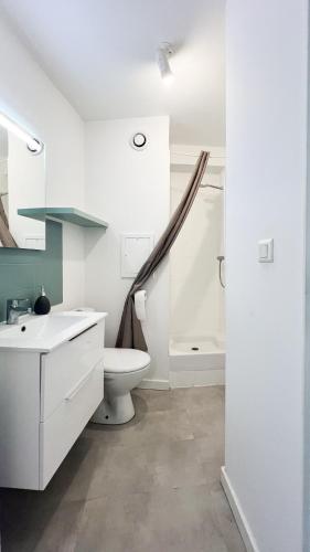 une salle de bain blanche avec un lavabo et des toilettes dans l'établissement CosyNest, à Avignon