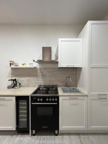 a kitchen with a black stove and a sink at Casa nel vicolo in Montichiari