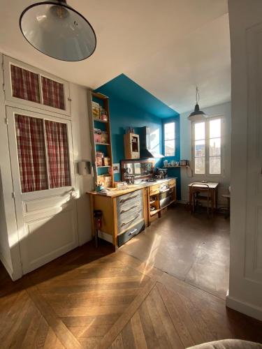 Il comprend une cuisine avec des murs bleus et une porte blanche. dans l'établissement Chambre bleue et or 16m2 chez l'habitant dans appartement 100m2 centre ville, à Rennes