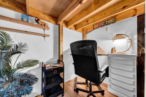 a black chair in a room with a desk at Zen Jungle House by Busch Gardens Sleeps 12 with Outdoor Games & Detached Play Space! in Tampa