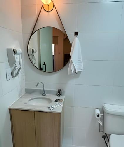 a bathroom with a sink and a mirror at Diamante de Sorocaba! Piscina incrível! in Sorocaba