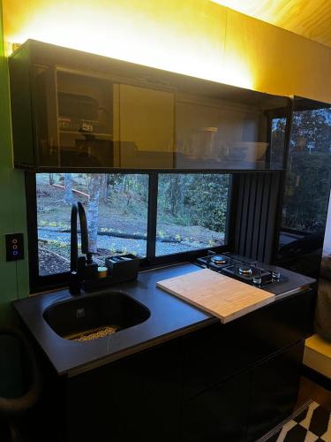 a kitchen with a sink and a counter with a window at Tiny House Minimalista en la Naturaleza, El Retiro in El Retiro